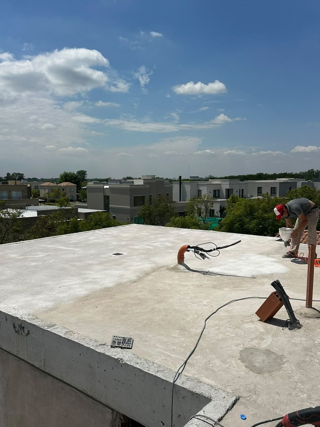 Operario proyectando corcho sobre una losa